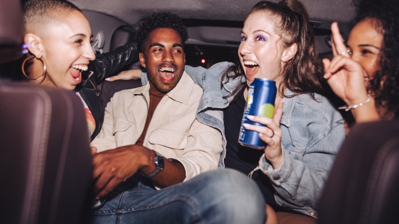 Cheerful friends having fun in the back seat of a car.